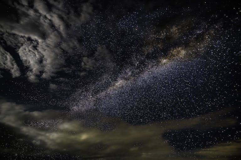 A breathtaking photo capturing the Milky Way galaxy with stars and clouds in a dark, starry sky.