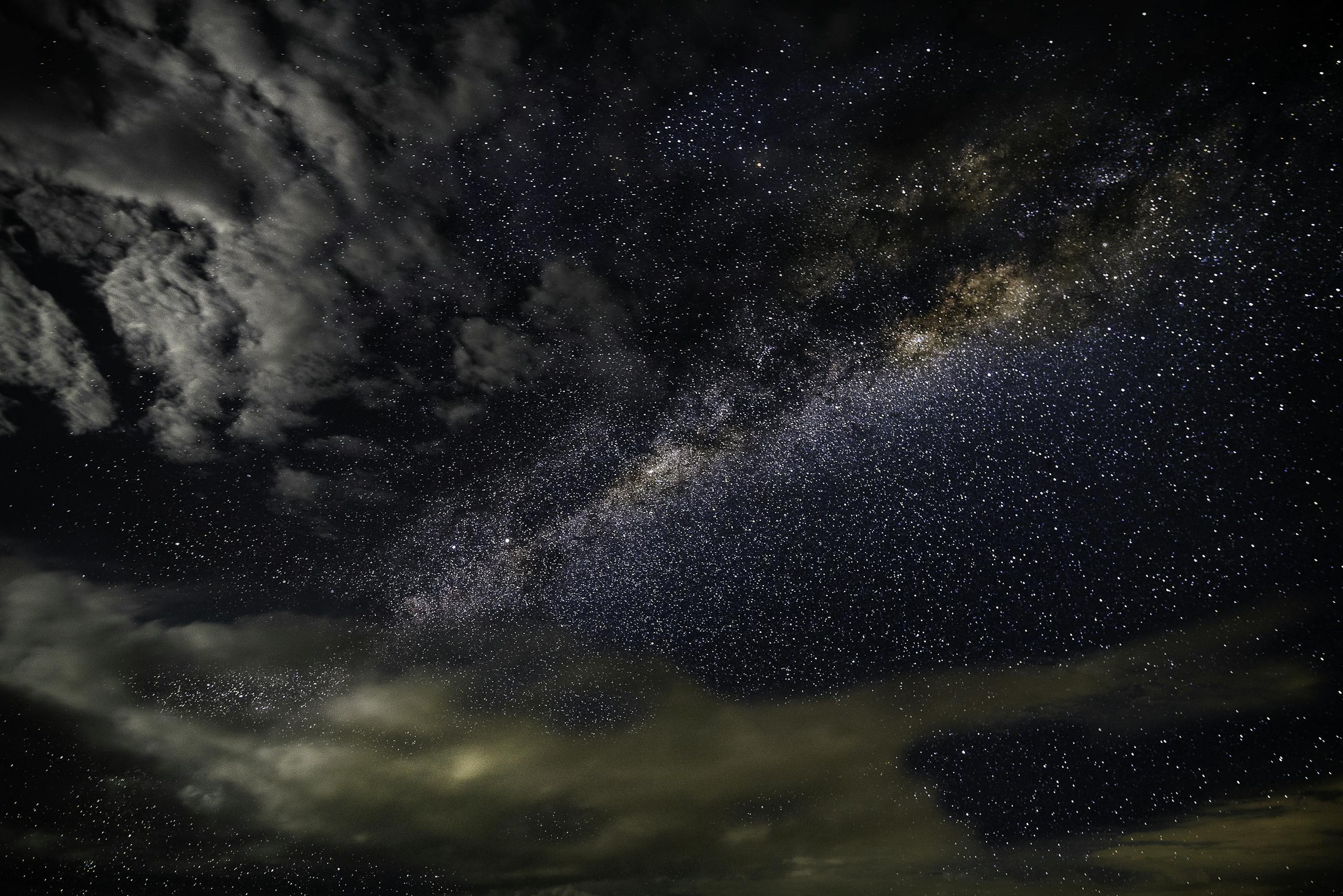 A breathtaking photo capturing the Milky Way galaxy with stars and clouds in a dark, starry sky.