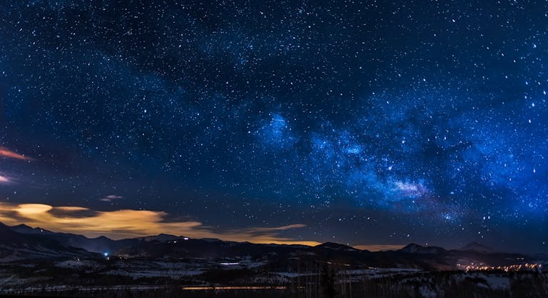 A breathtaking view of the Milky Way galaxy illuminating the night sky over mountains.