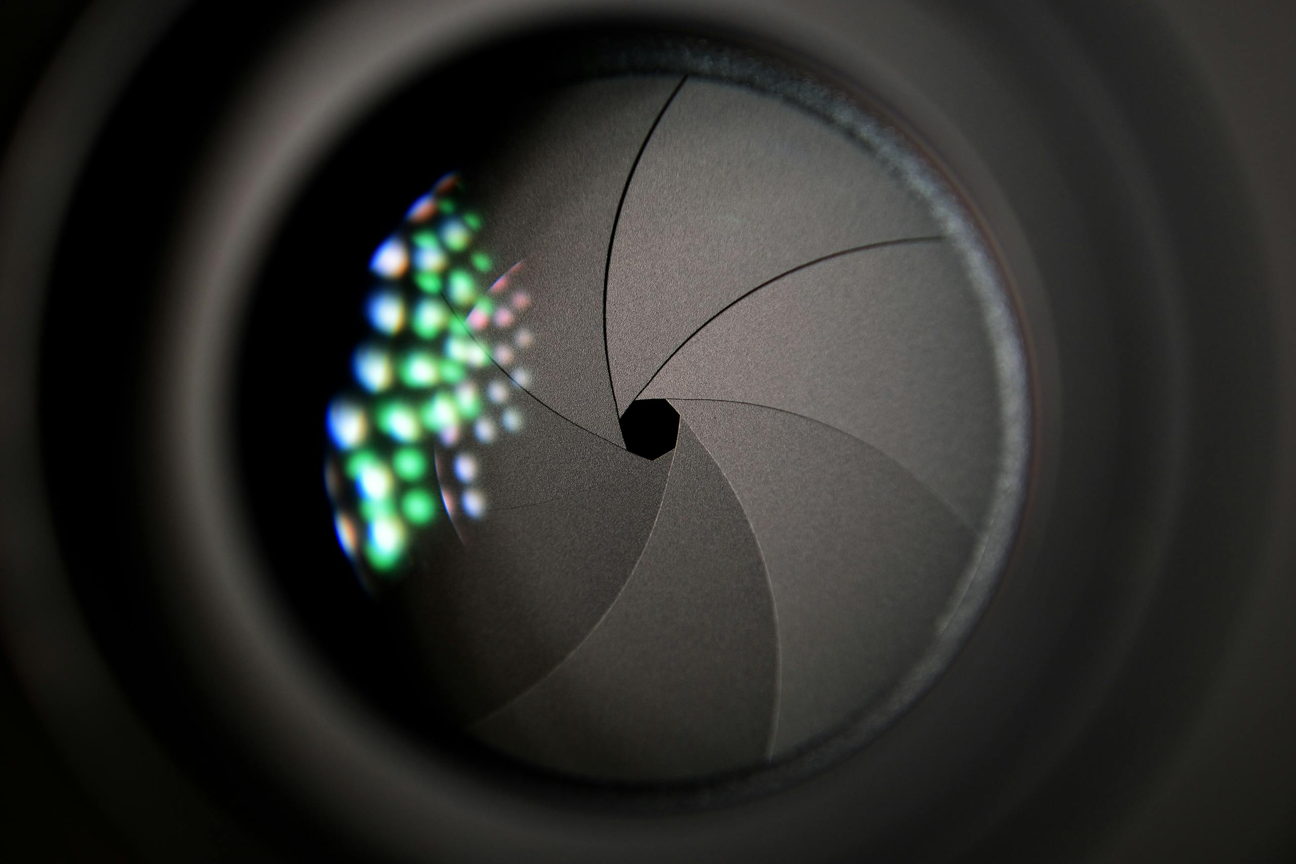 Tiny Multicolor Metalenses Could Transform Cameras in Phones, Drones, and Satellites Detailed image of a camera lens aperture showing mechanical blades.