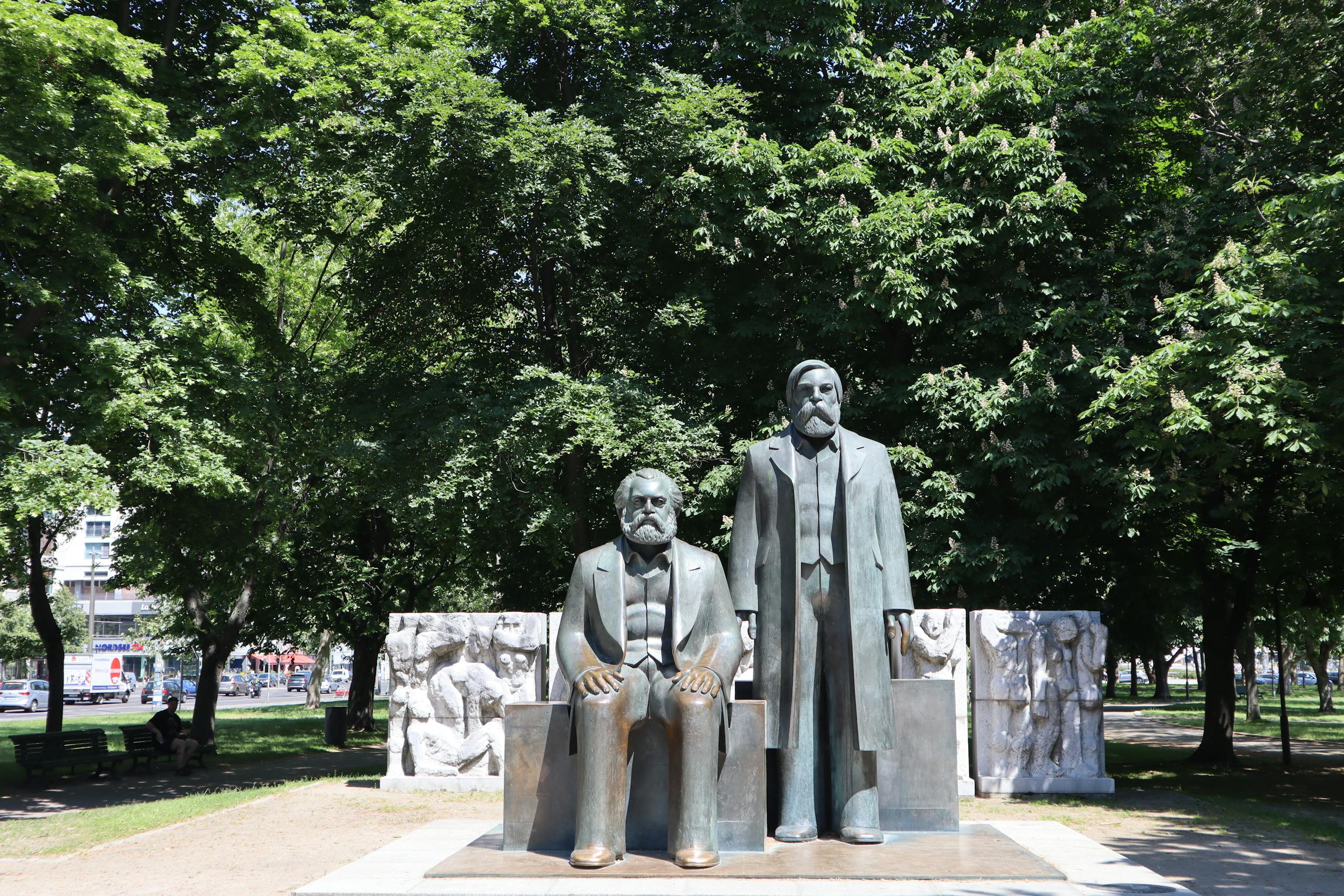 Statues of Karl Marx and Friedrich Engels in Berlin park, sunny day.