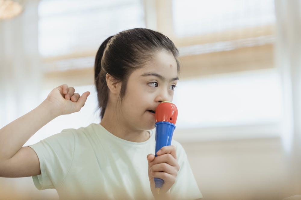 Stanford Scientists Reverse Autism Symptoms in Mice by Targeting a Key Brain Region Young girl singing into a toy microphone, expressing joy and creativity indoors.