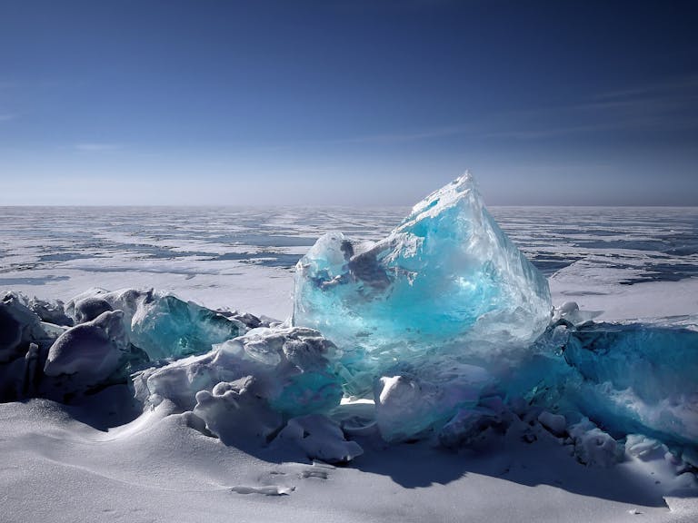 Retreating Glaciers Could Be Sending Fewer Nutrients to the Ocean, Scientists Warn Captivating ice formation on a frozen lake under a bright blue sky during winter.