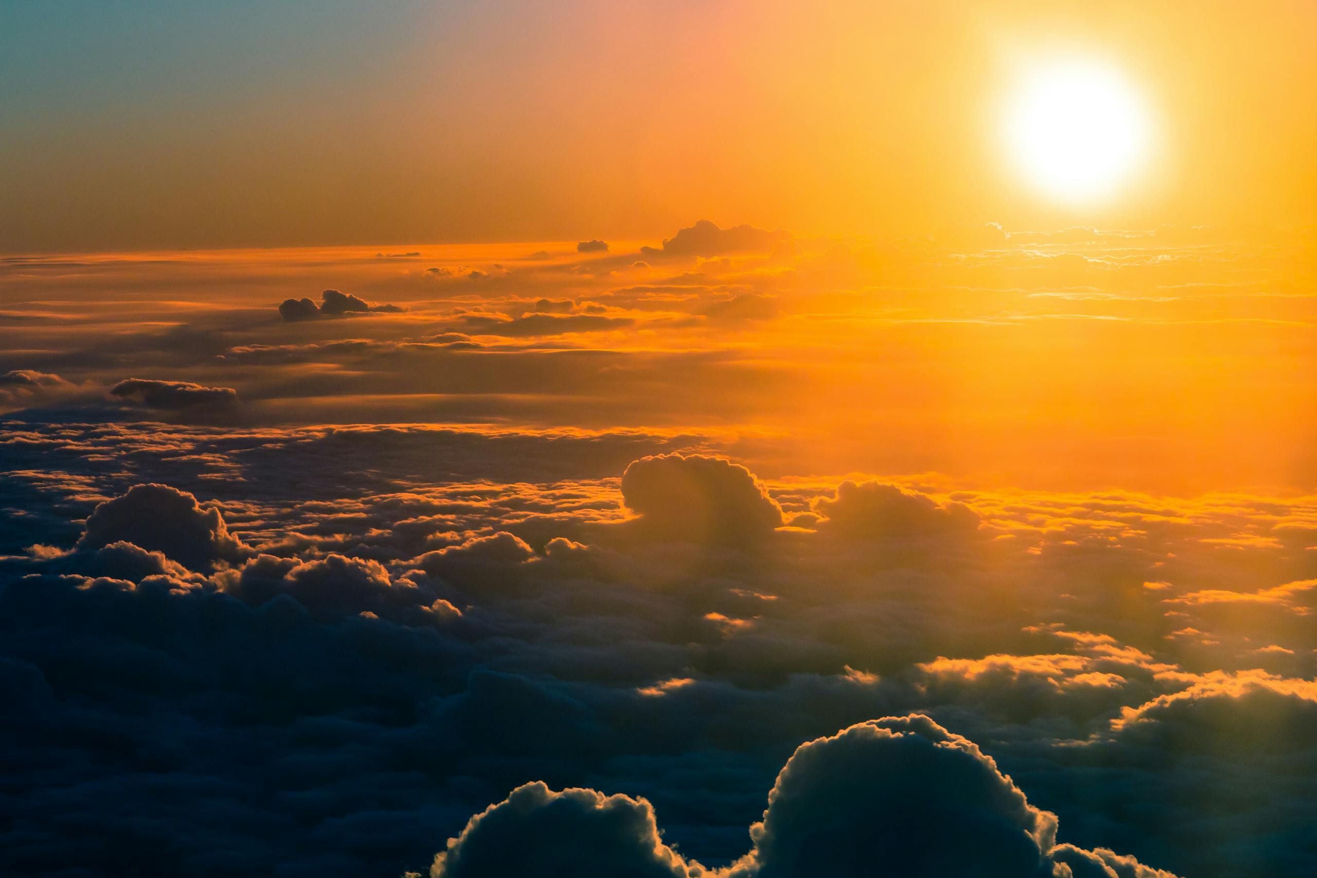 Increasing Heat Is Supercharging Arctic Climate and Weather Extremes Stunning aerial view of a dramatic sunset over thick clouds, glowing horizon.