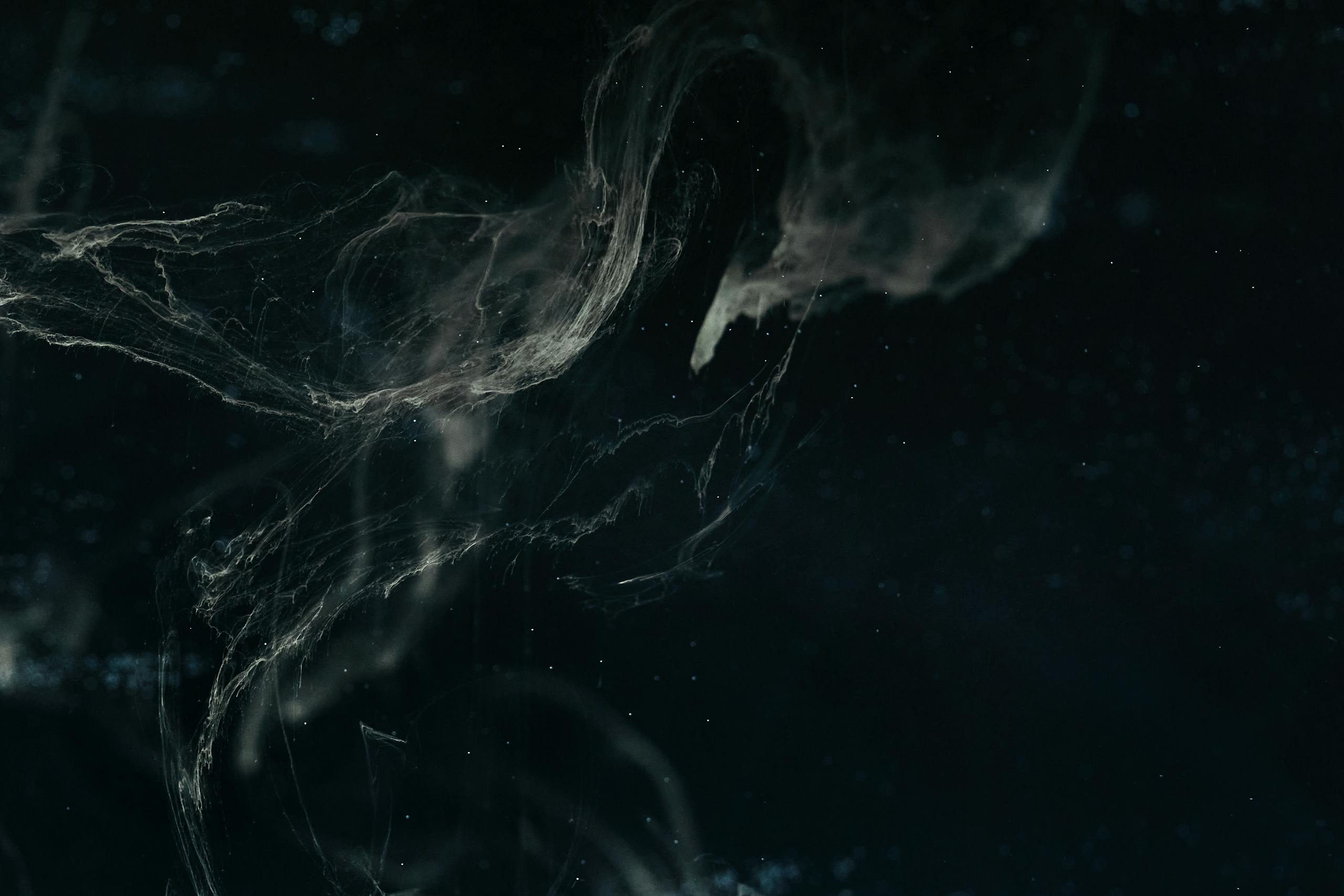 Abstract dark nebula image with swirling patterns and ethereal textures creating a cosmic feel.