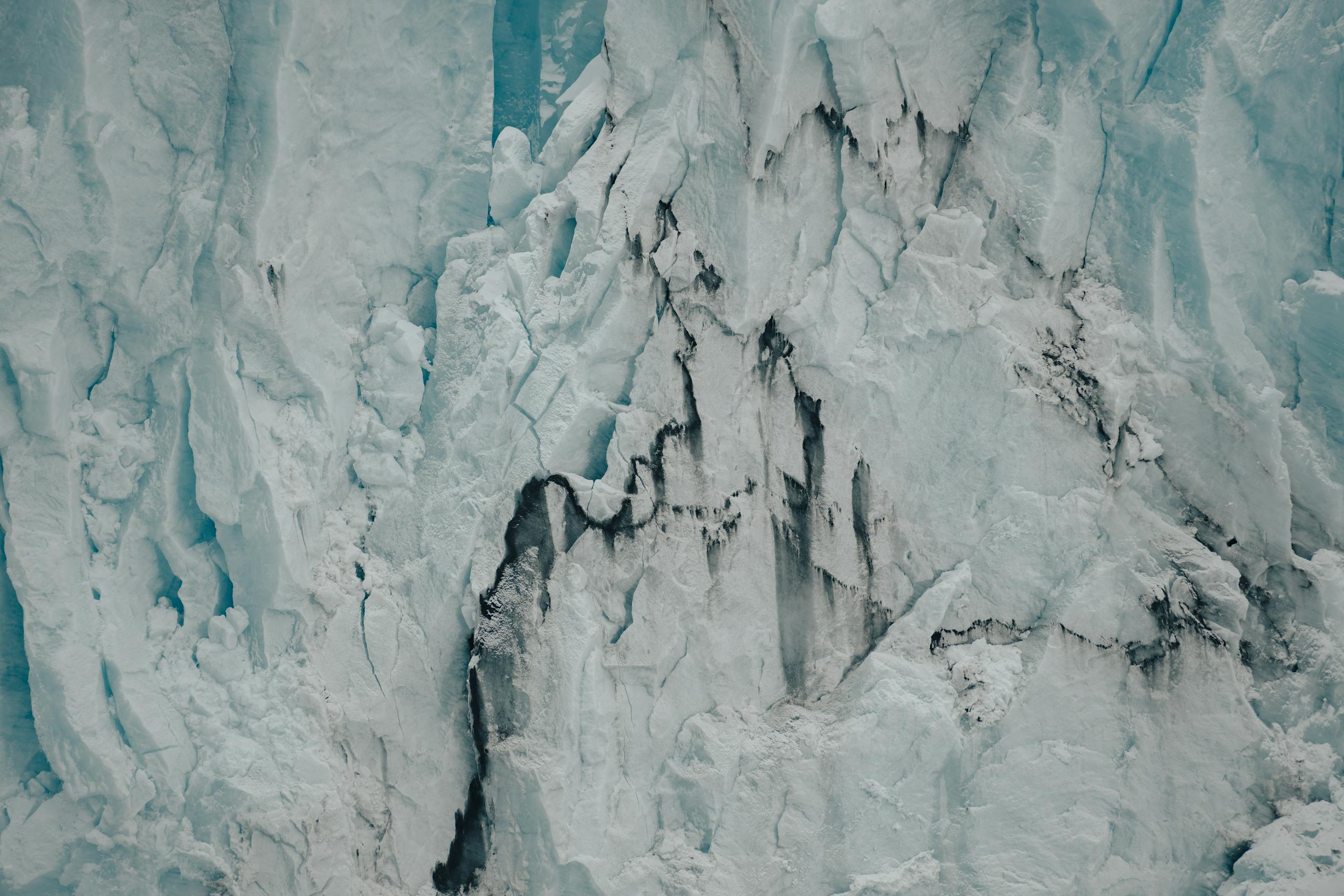 Close-up view of a rugged glacier ice cliff, showcasing nature's icy magnificence.