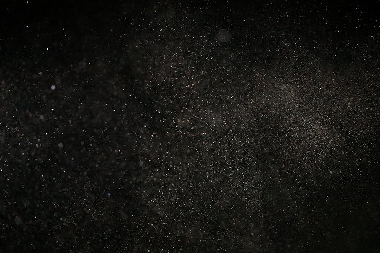 Dark textured background with floating particles, perfect for abstract designs.