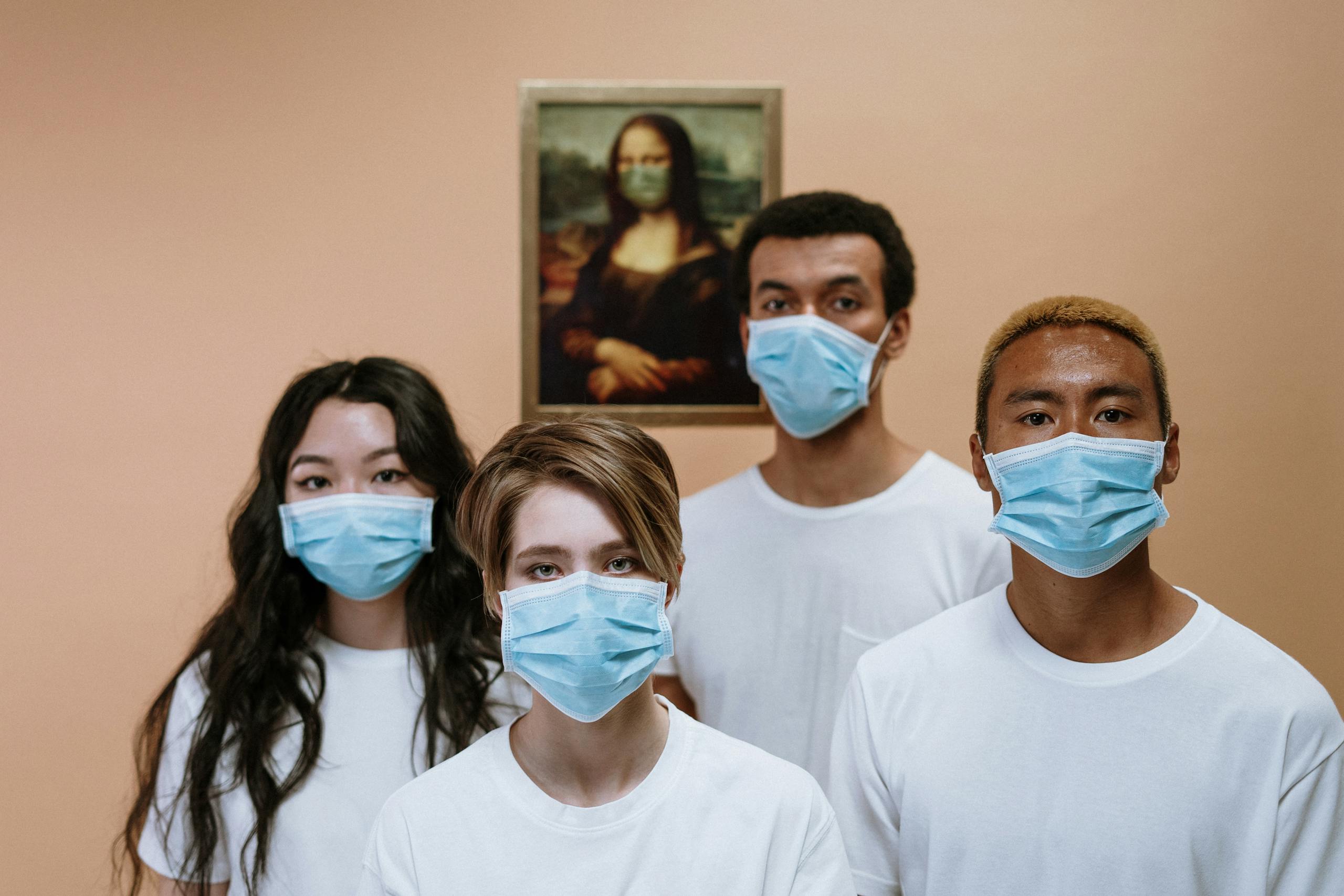 A diverse group wearing masks stands in front of a masked Mona Lisa painting.