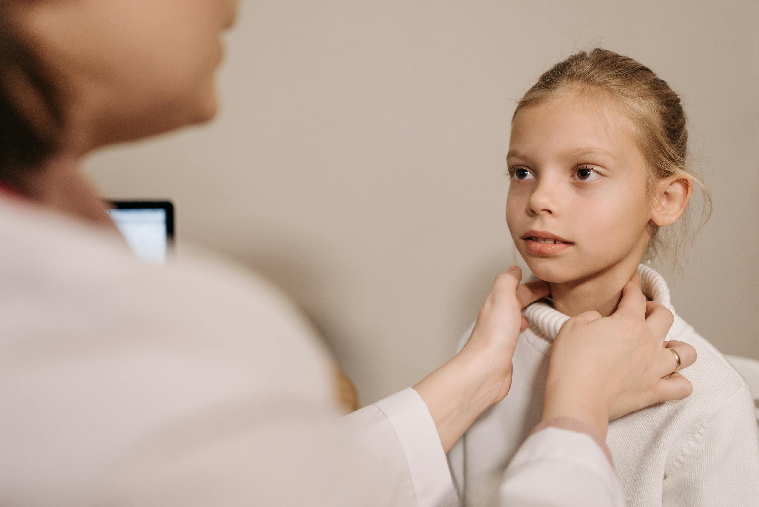 A doctor performing a medical check on a child during an appointment in a clinic.