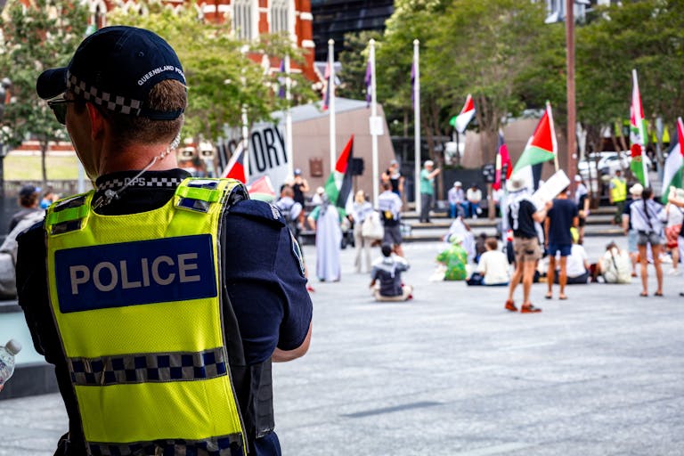 A police officer oversees a peaceful protest in Brisbane City, Australia.