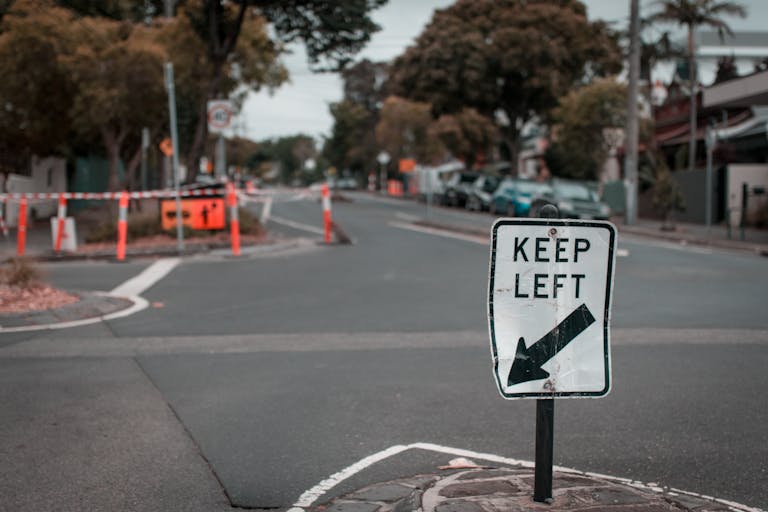 A suburban street view with a 'Keep Left' sign and road construction in Melbourne.