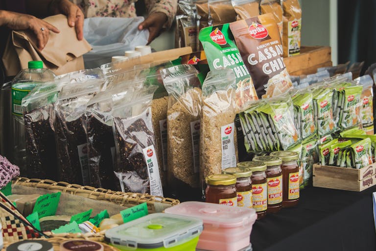 An assortment of packaged foods displayed on a market stall indoors, showcasing variety.