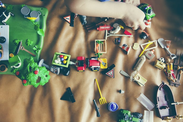 Children's hands playing with colorful toys on a mat, sparking creativity and fun.