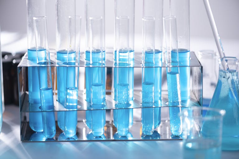Close-up of blue liquid in test tubes for chemistry experiments in a laboratory setting.