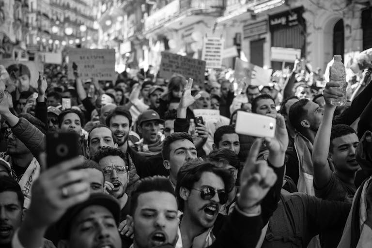 Crowded Algerian street protest captured with intensity and detail.