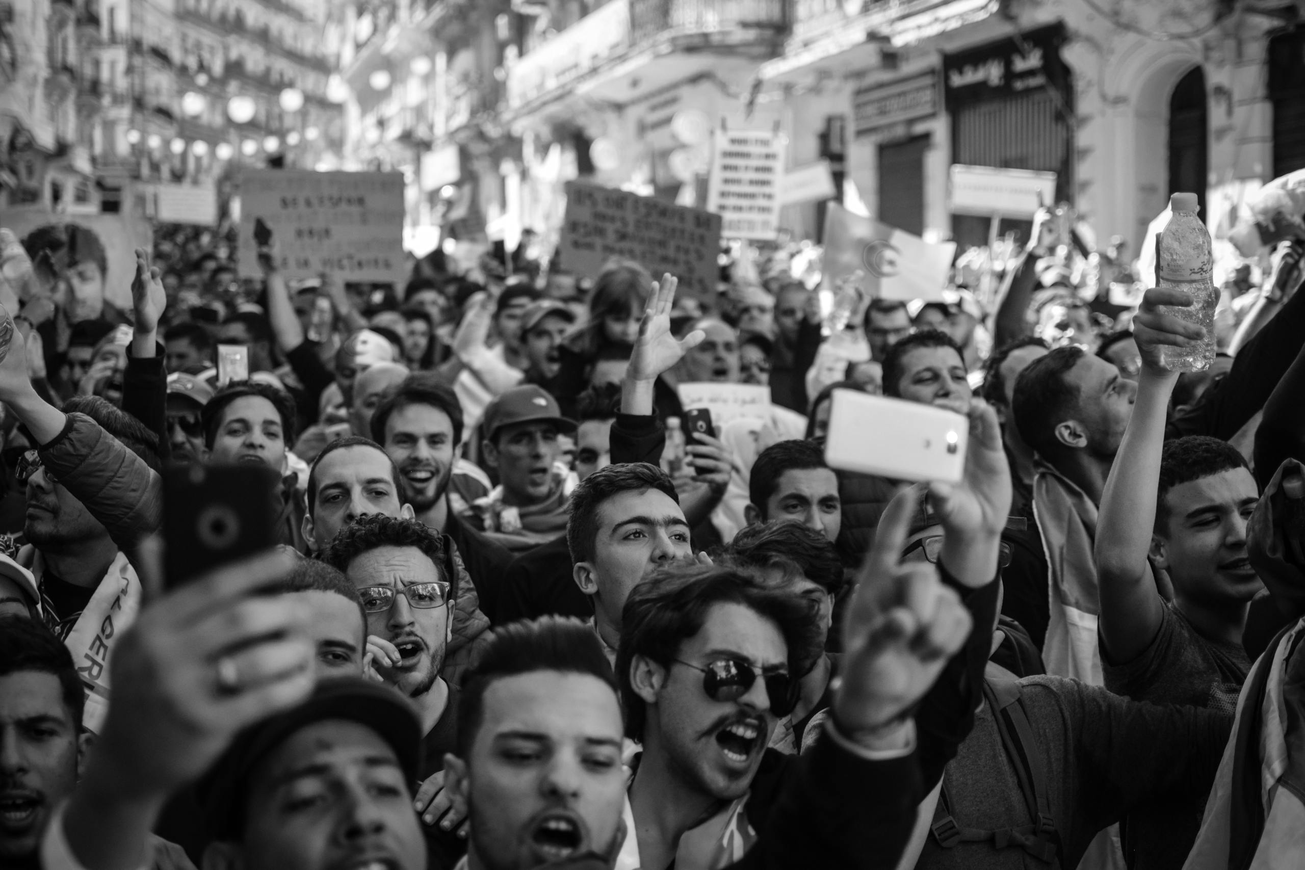 Crowded Algerian street protest captured with intensity and detail.