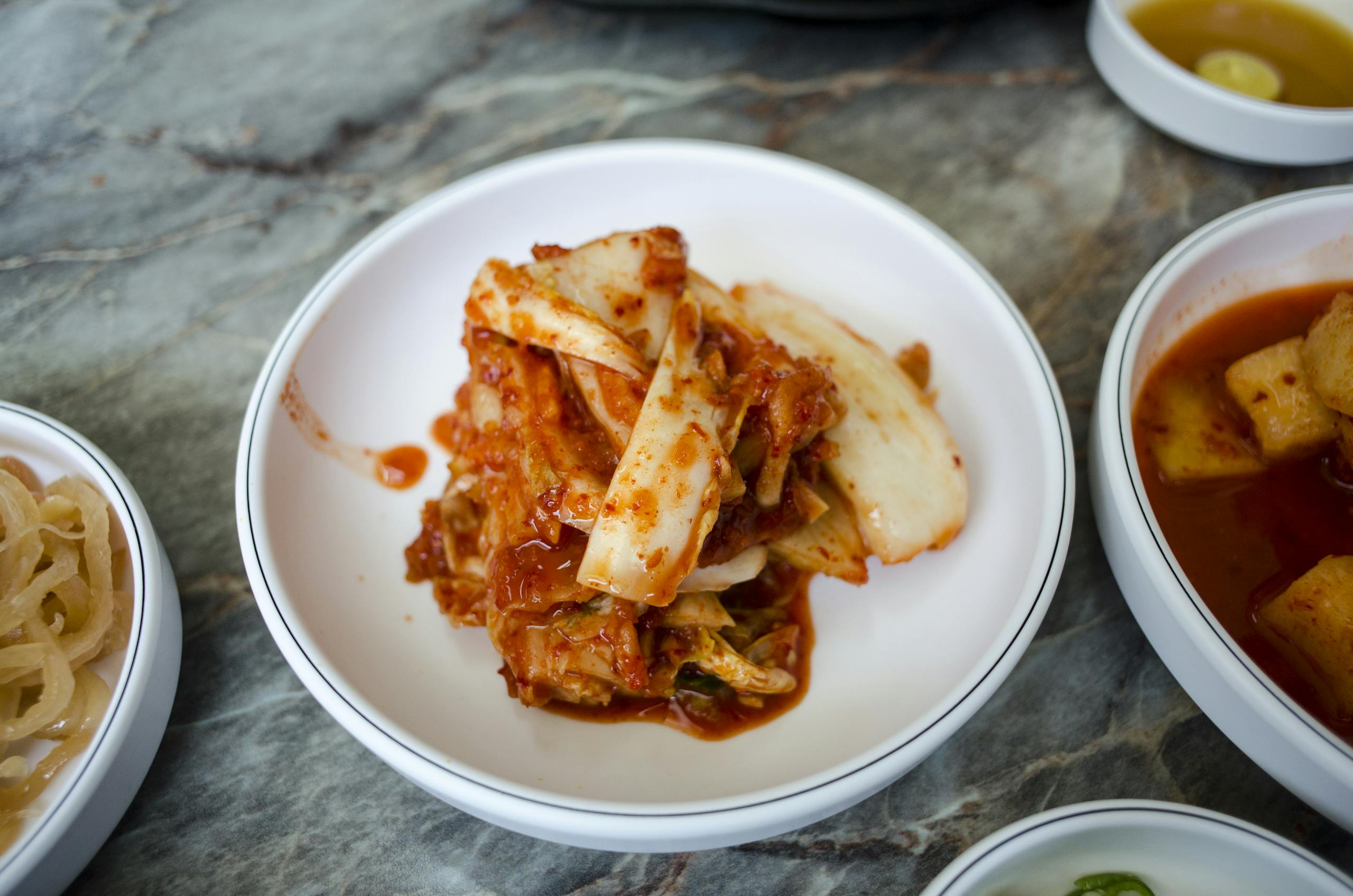 Delicious traditional Korean kimchi served in a white bowl, perfect for Asian cuisine enthusiasts.
