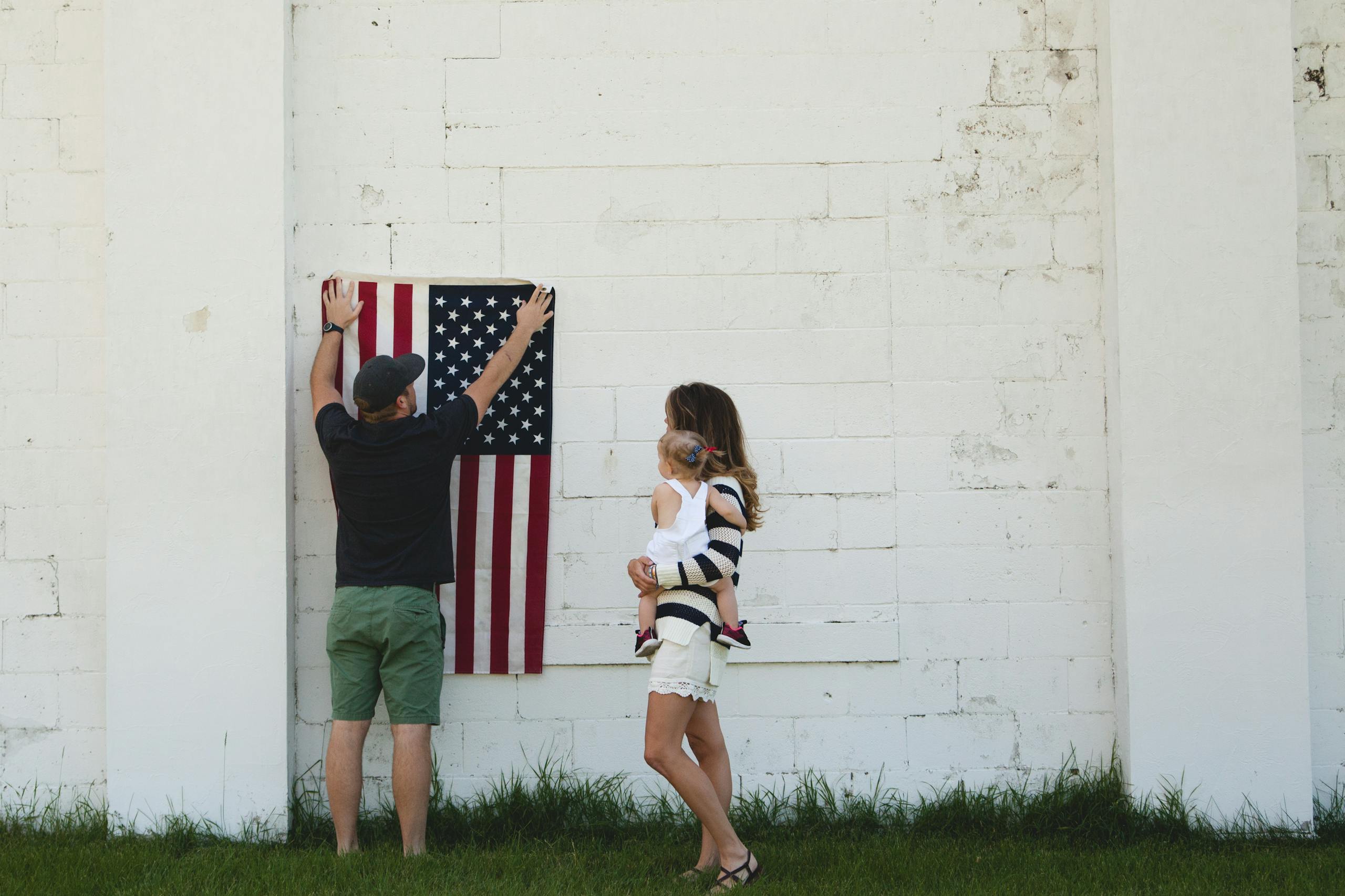 Family celebrating with American flag outdoors, symbolizing patriotism and togetherness.