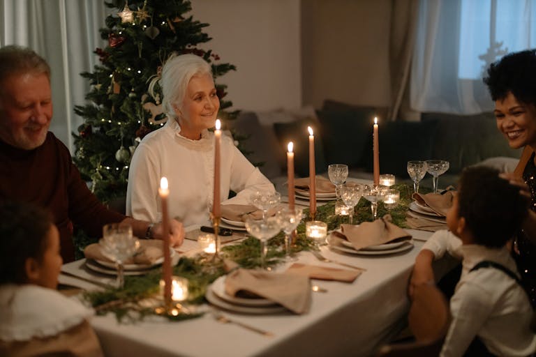 Family enjoying a festive Christmas dinner with smiles and holiday decorations.