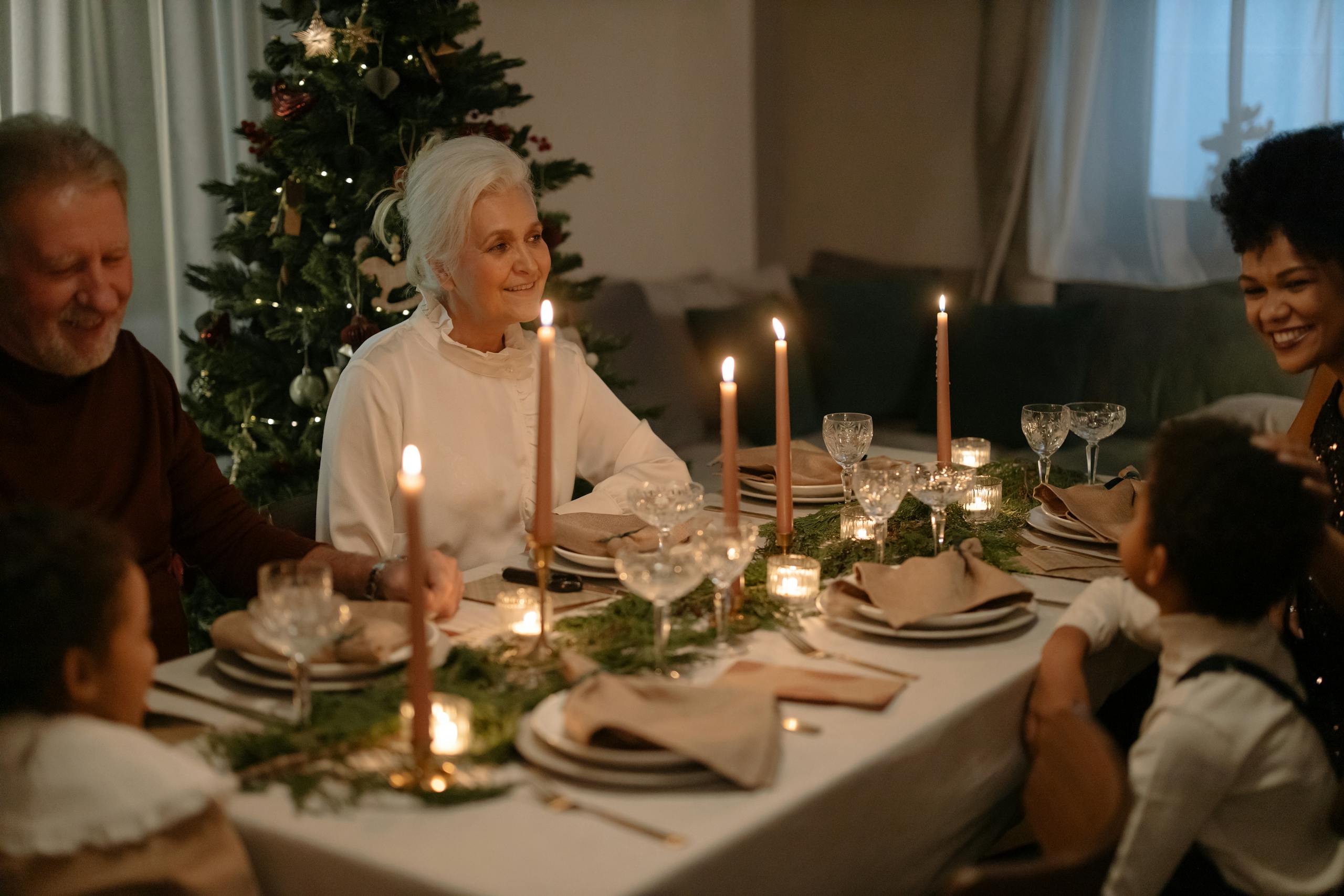 Family enjoying a festive Christmas dinner with smiles and holiday decorations.