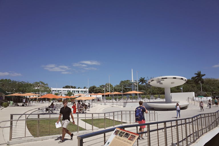 Outdoor campus area at a university in Coral Gables, FL, with students and modern architecture.