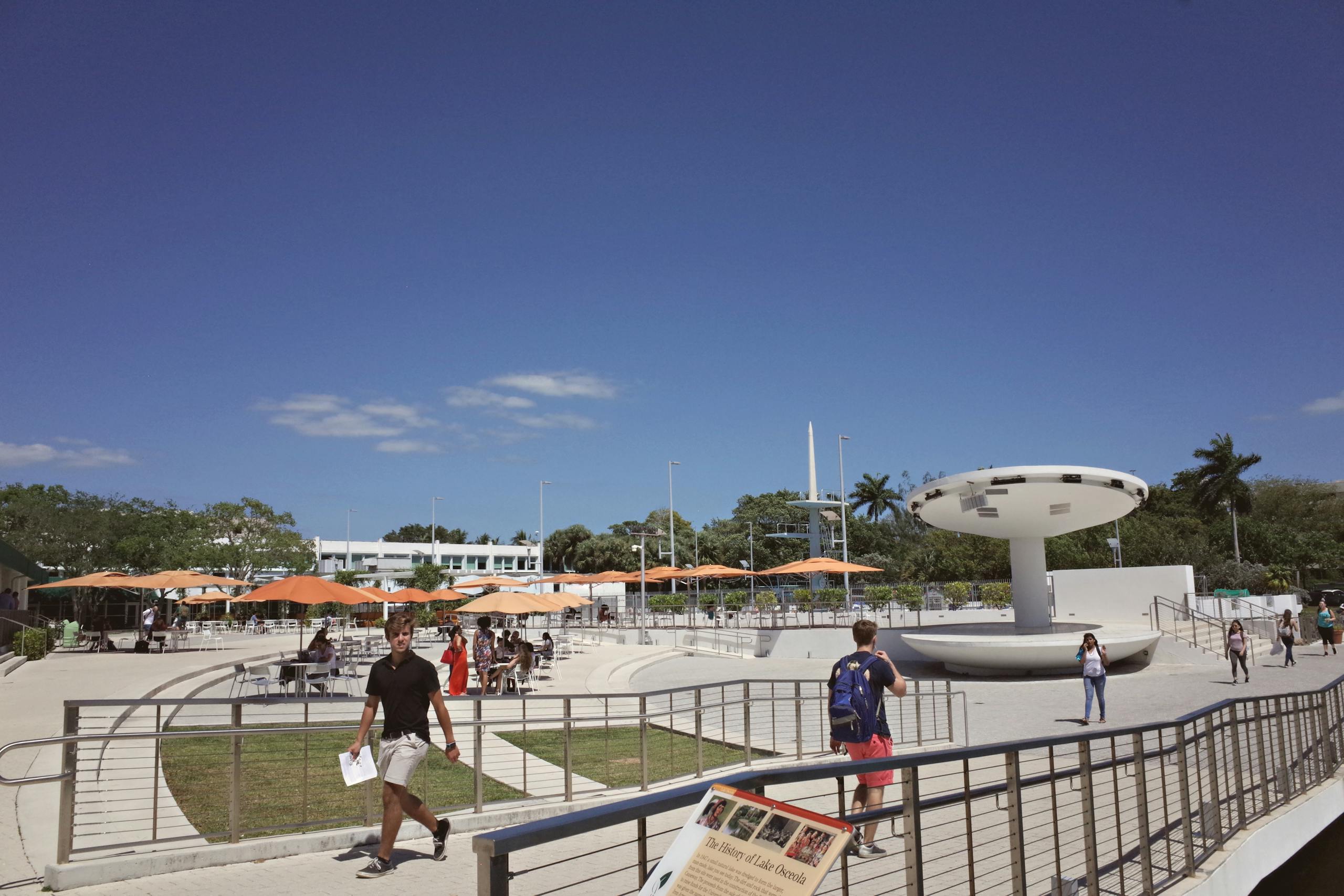 Outdoor campus area at a university in Coral Gables, FL, with students and modern architecture.