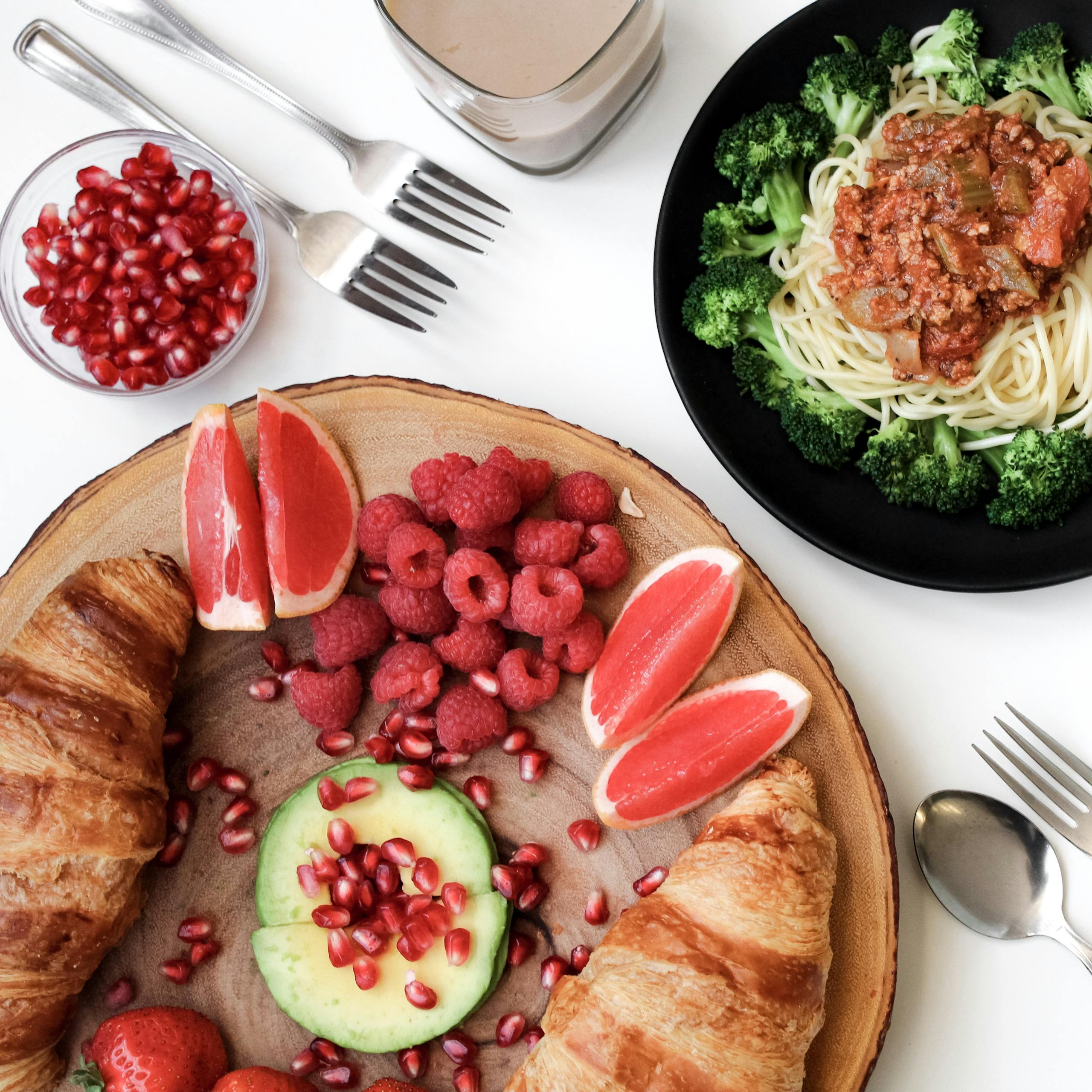 A vibrant breakfast spread with croissants, pasta, and fresh fruits, perfect for food lovers.