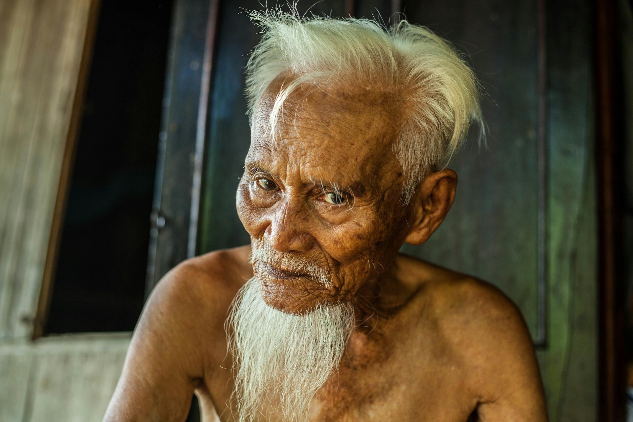 Close-up portrait of a senior man with a long beard in Vietnam.