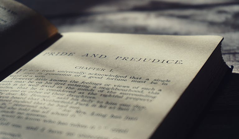 Close-up view of an open vintage page from Pride and Prejudice in warm sunlight.