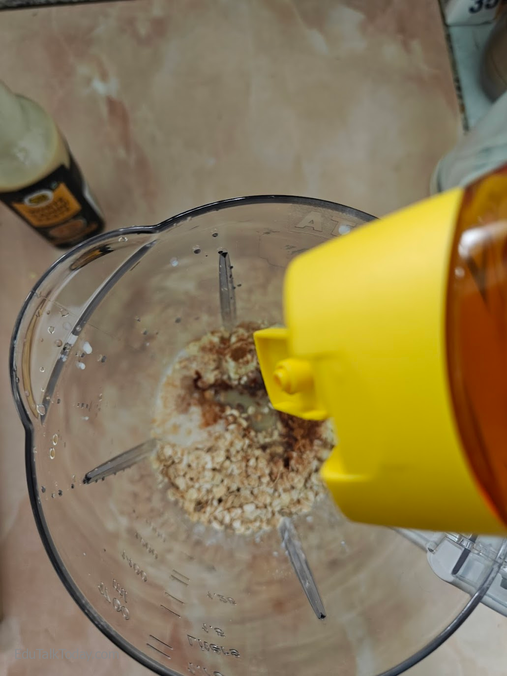 Oats Tahini Protein Smoothie Honey being added to the blender jar