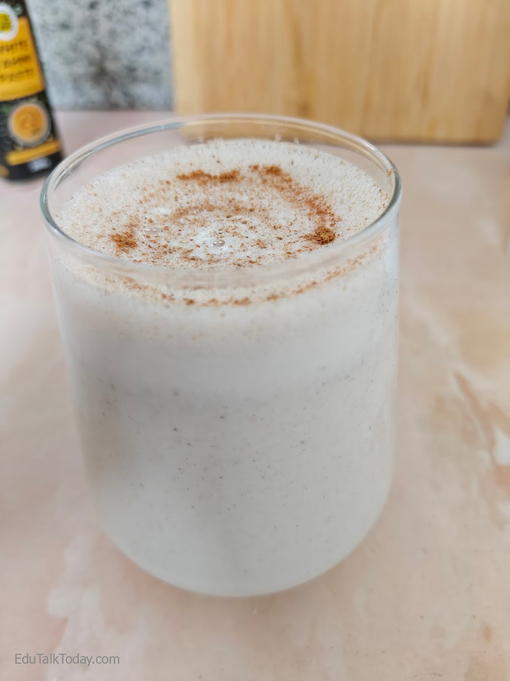The oats tahini protein smoothie in a jar with cinnamon sprinkled on top