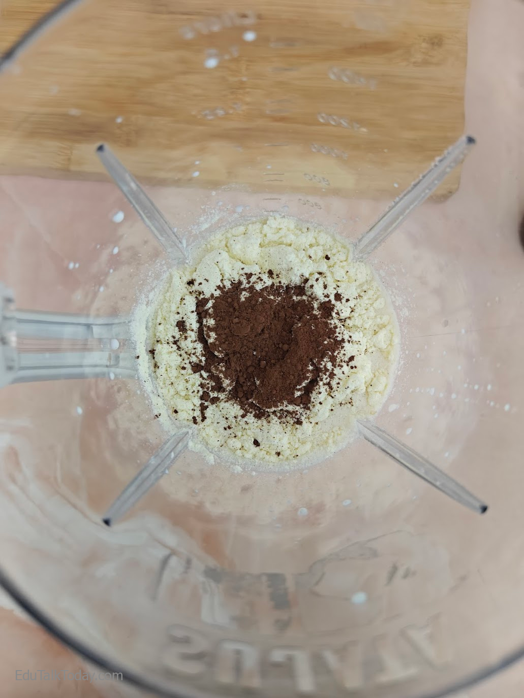 Cocoa powder and protein powder added to blender with oats and milk for smoothie