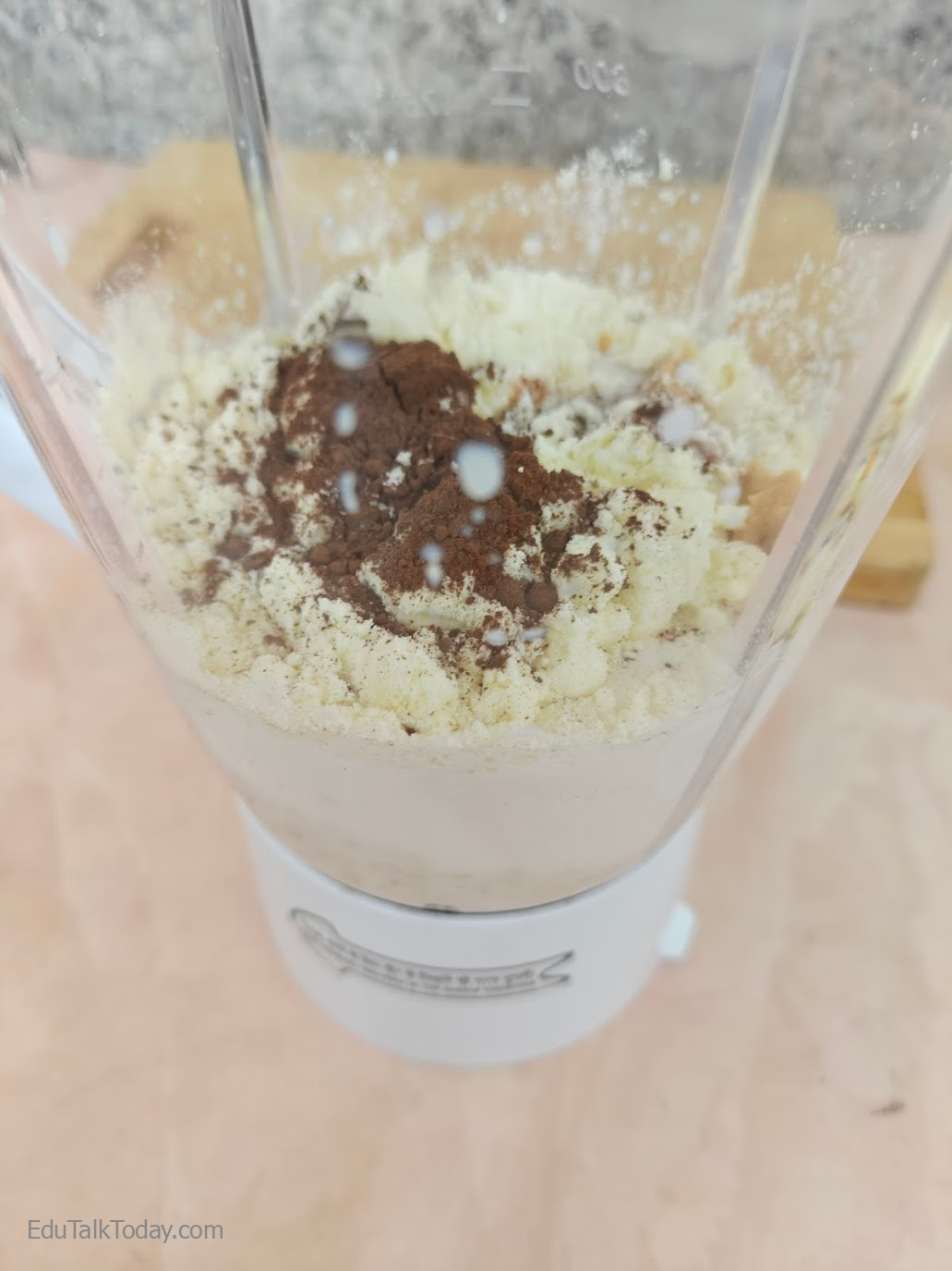 Peanut Butter Oats Smoothie Smoothie ingredients including milk, oats, cocoa powder, protein powder, and peanut butter inside blender jar