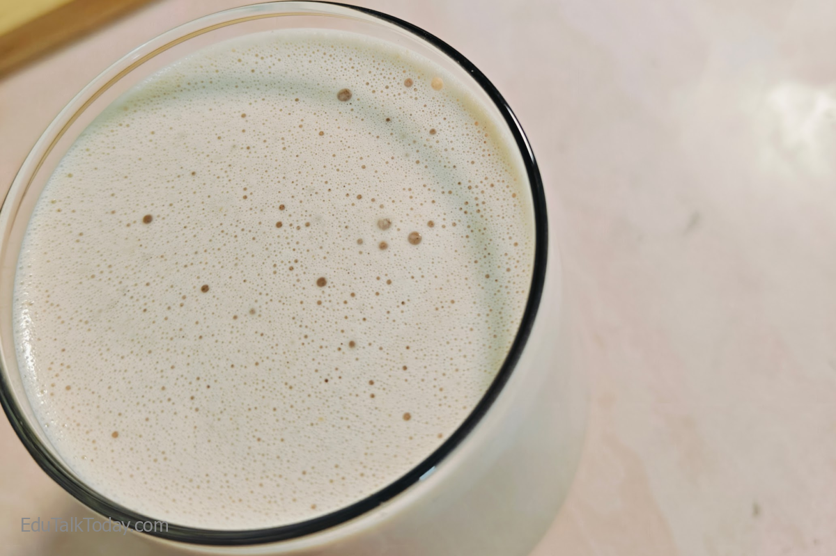 Peanut butter oats smoothie in a glass with creamy frothy texture on top